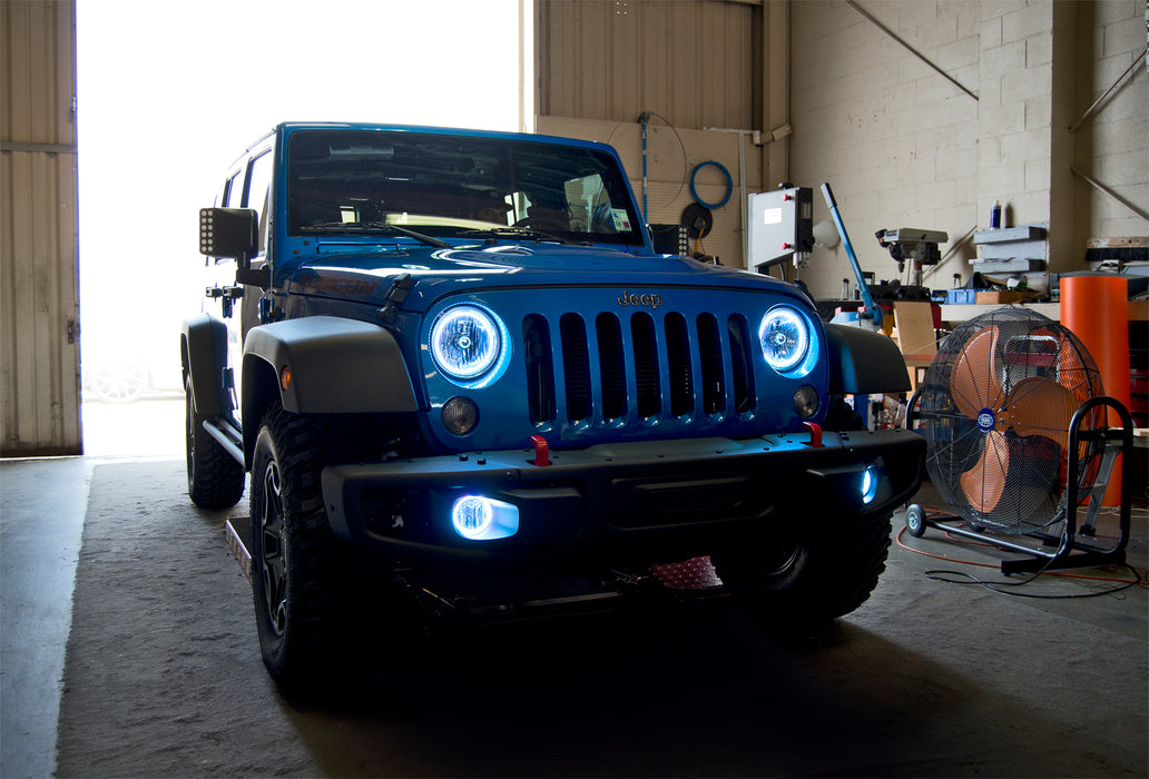 Three quarters view of a Jeep Wrangler JK with white LED headlight and fog light halos installed.