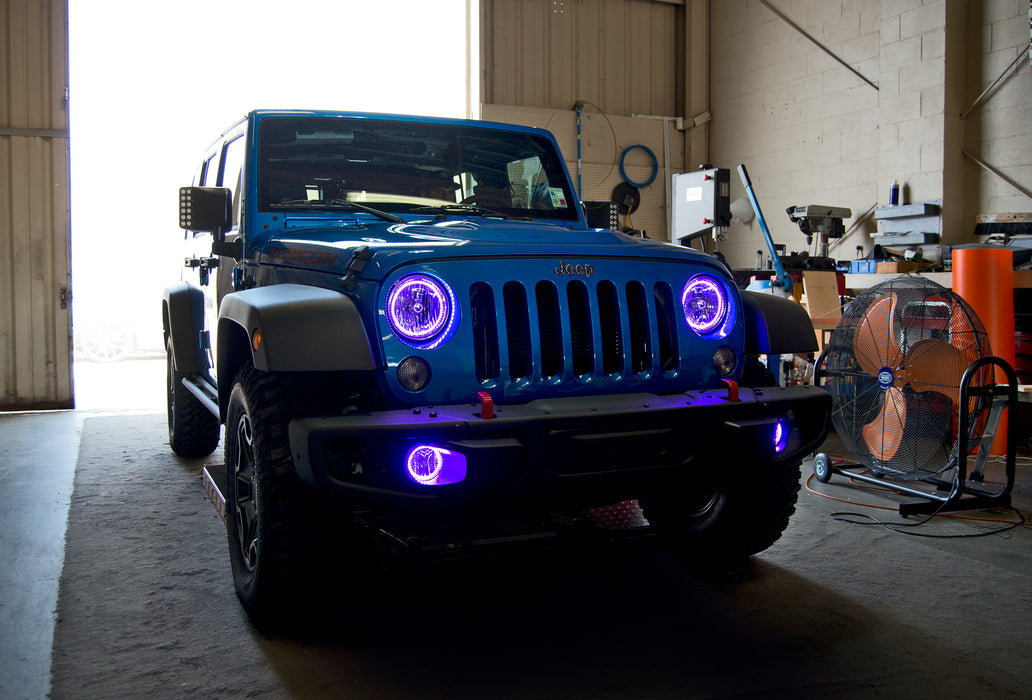 Three quarters view of a Jeep Wrangler JK with purple LED headlight and fog light halos installed.