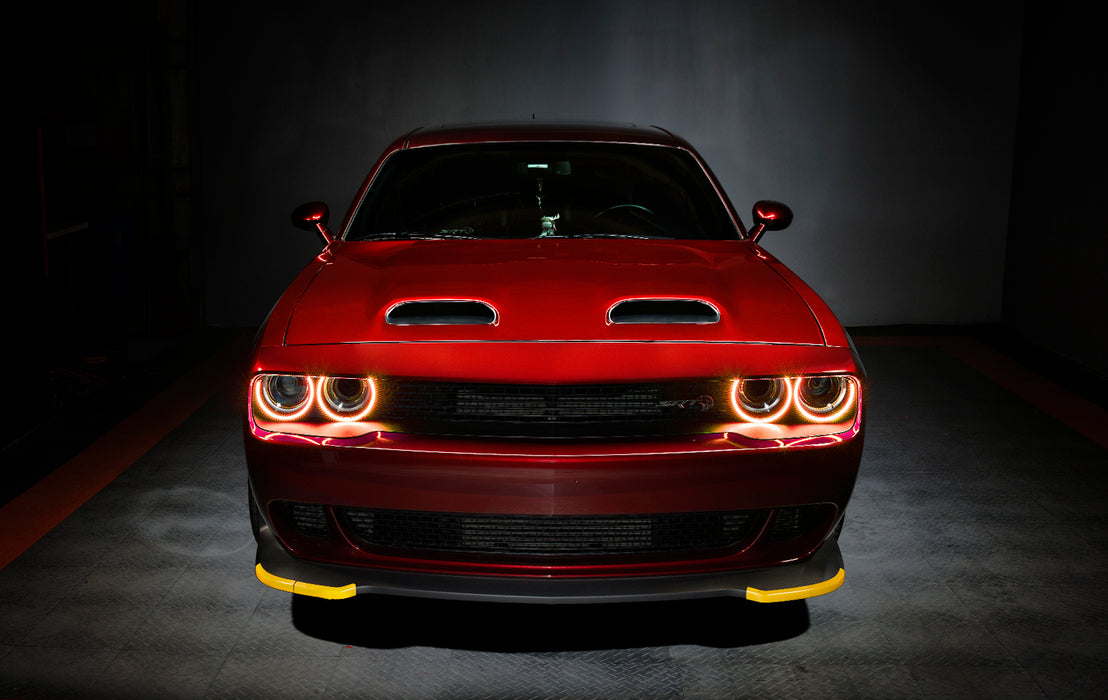 Front view of a red Dodge Challenger with amber LED headlight halo rings installed.