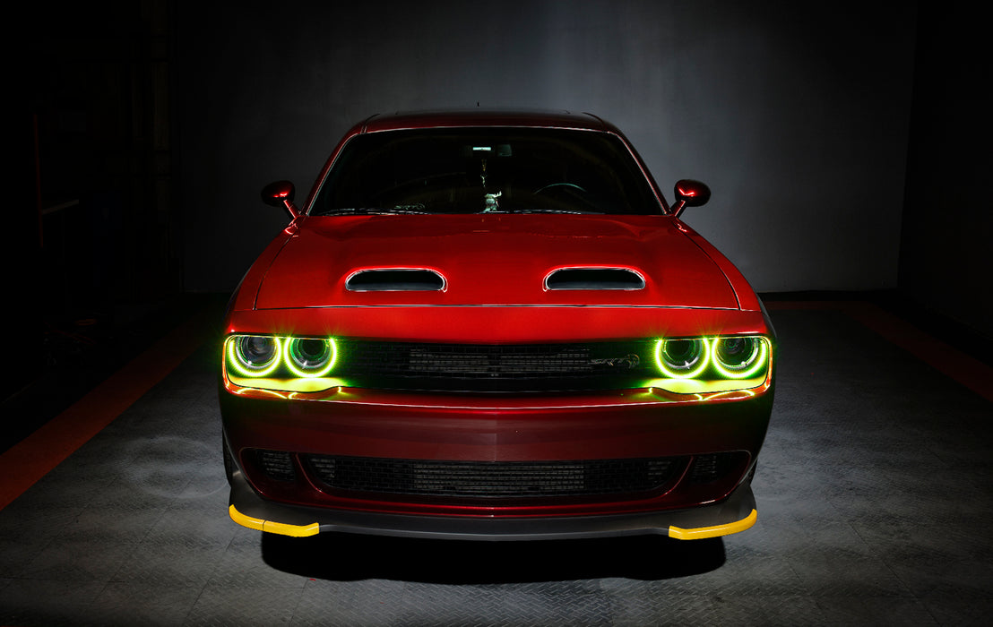 Front view of a red Dodge Challenger with yellow LED headlight halo rings installed.