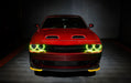 Front end of a red Dodge Challenger with yellow halo headlights.
