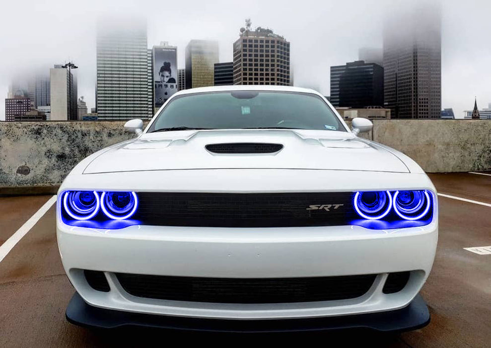Front end of a white Dodge Challenger with blue LED headlight halo rings installed.