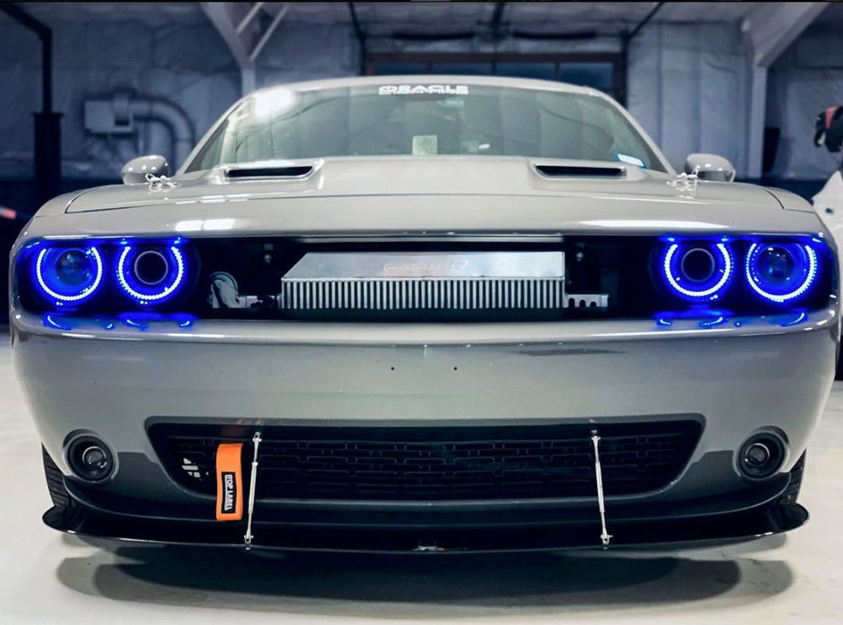 Front end of a silver Dodge Challenger with blue LED headlight halo rings installed.