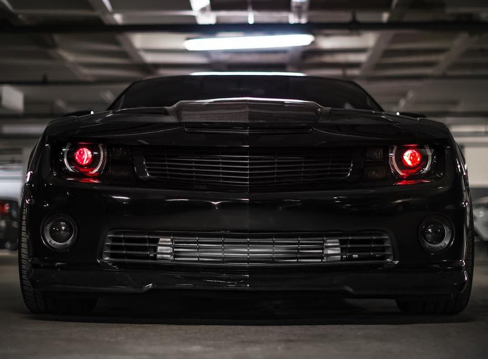 Front end of a black Chevrolet Camaro with red demon eye projectors.