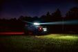 ORACLE Lighting wrapped Ford Bronco in an empty field at night, with a beam of light coming from the Integrated Windshield Roof LED Light Bar System.