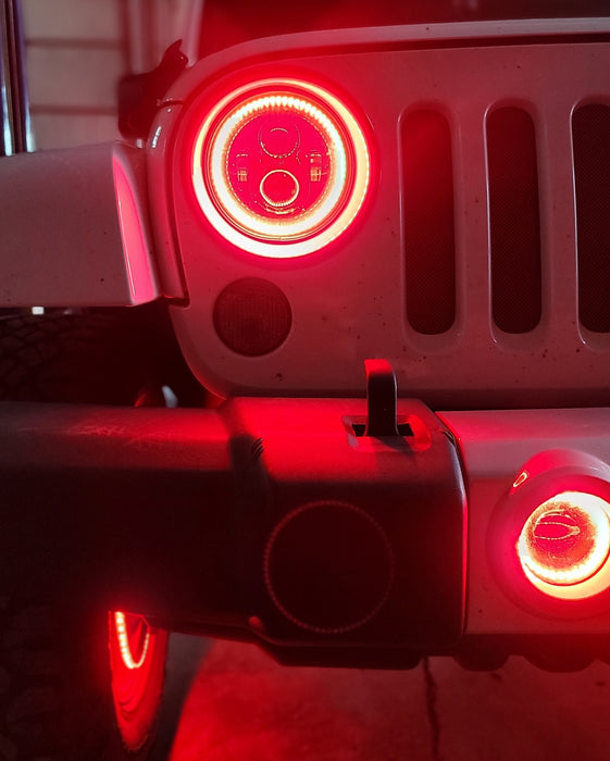 Close-up on the front end of a Jeep with High Performance 20W LED Fog Lights installed, and red halos on.