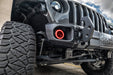 Close-up on the front bumper of a Jeep with High Performance 20W LED Fog Lights installed, and red halos on.