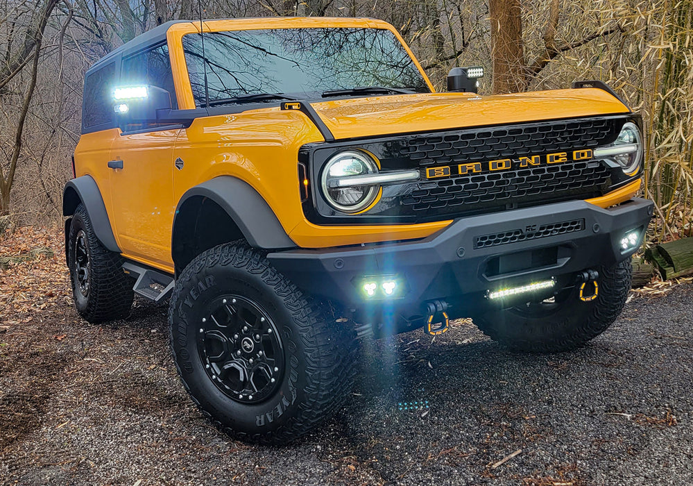 Yellow Ford Bronco riding through the woods with LED Off-Road Side Mirrors turned on.