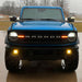 Front view of a blue Ford Bronco in the rain with LED Off-Road Side Mirrors turned on.