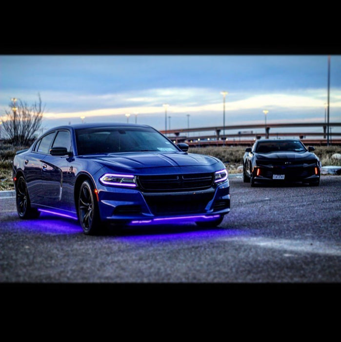 Three quarters view of a blue Dodge Charger with pink headlight DRLs.