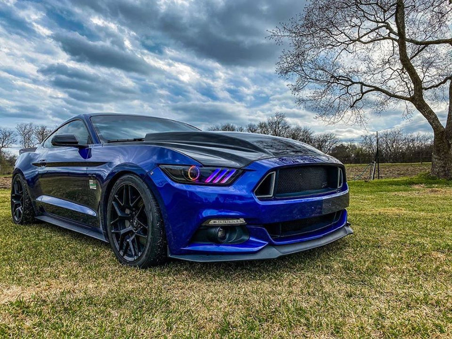 Blue Ford Mustang in the grass outside with rainbow DRL and halos