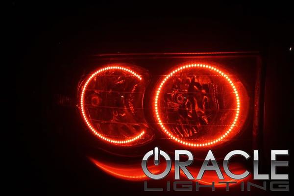 Close-up of a Dodge Ram headlight unit with red LED halo rings installed.