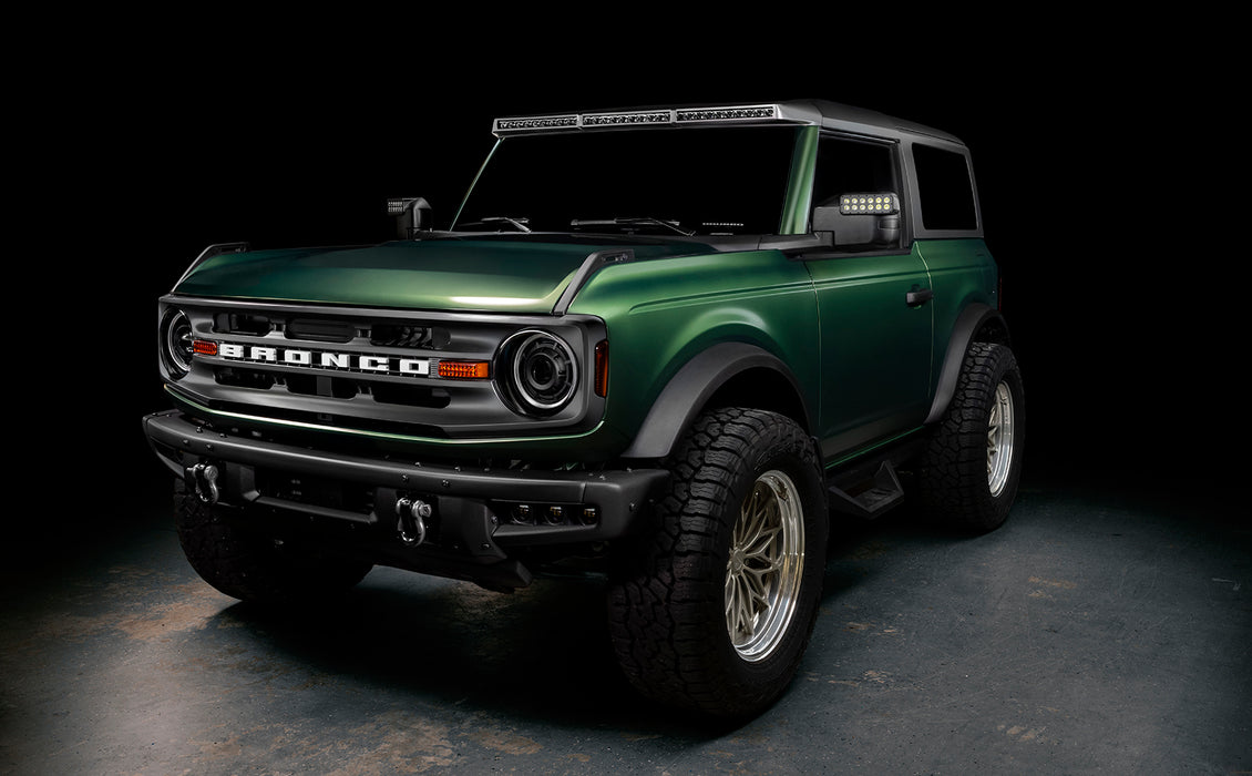 Three quarters view of a green Ford Bronco with multiple ORACLE Lighting products installed, including Oculus Headlights.