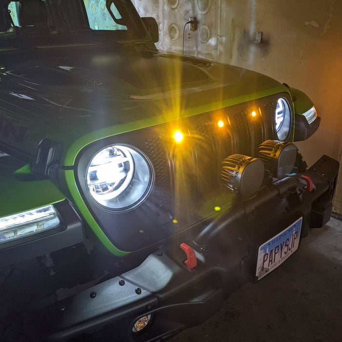 Front end of a Jeep Wrangler JL with amber Pre-Runner Style LED Grill Light Kit installed.