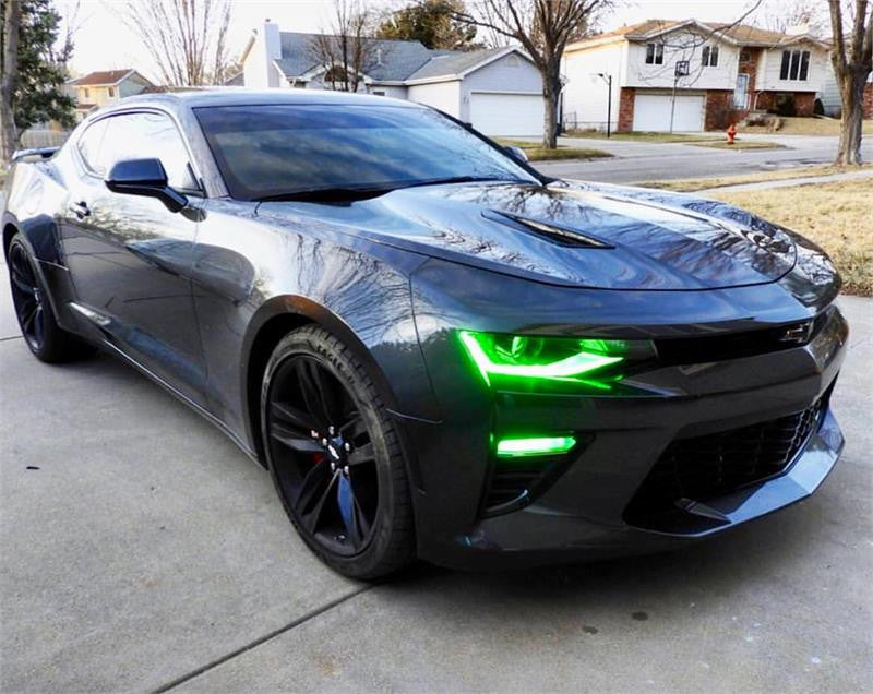 Three quarters view of a black Chevrolet Camaro with green headlight and fog light DRLs.