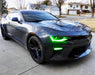 Three quarters view of a black Chevrolet Camaro with green headlight and fog light DRLs.