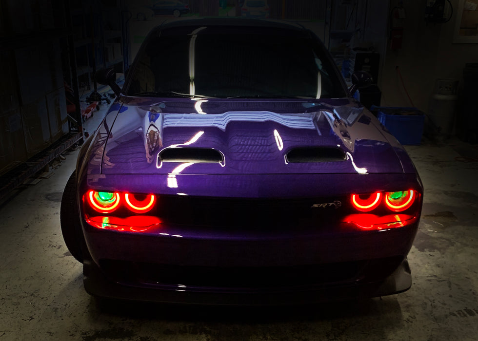 Dodge Challenger with green demon eye projector headlights.