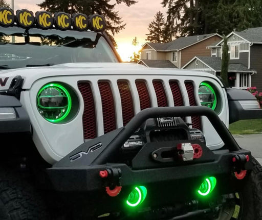 Front end of a white Jeep Wrangler JL equipped with green headlight and fog light DRLs.