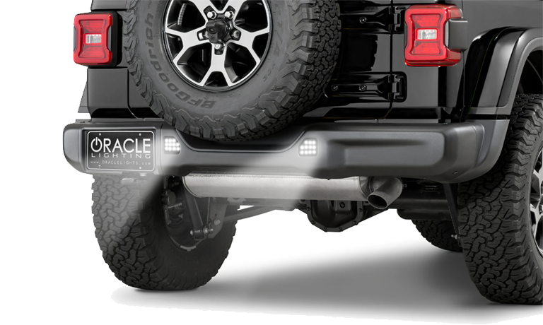 Rear end of a Jeep with ORACLE Lighting Rear Bumper LED Reverse Lights installed, and shining brightly.