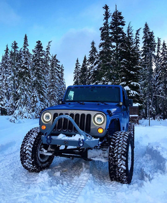 Jeep Wrangler in the snow equipped with 7" High Powered LED Headlights.