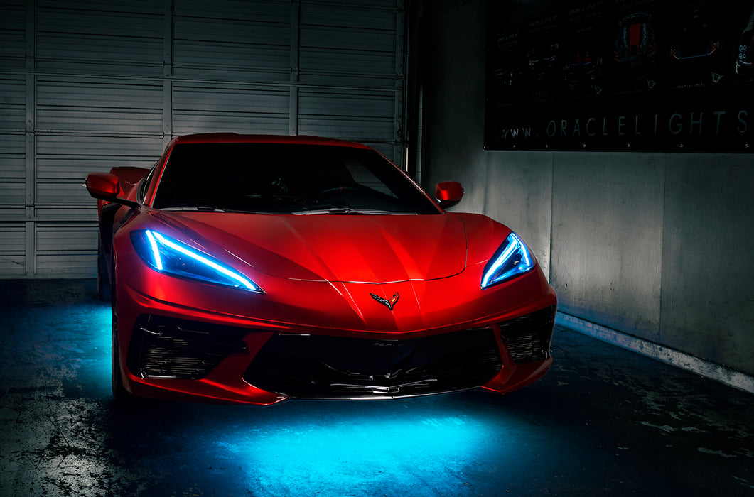 Red Corvette in a garage with cyan headlight DRLs.