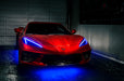 Red Corvette in a garage with blue headlight DRLs.