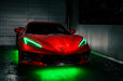 Red Corvette in a garage with green headlight DRLs.