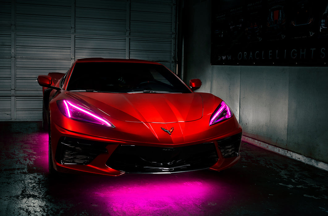 Red Corvette in a garage with pink headlight DRLs.