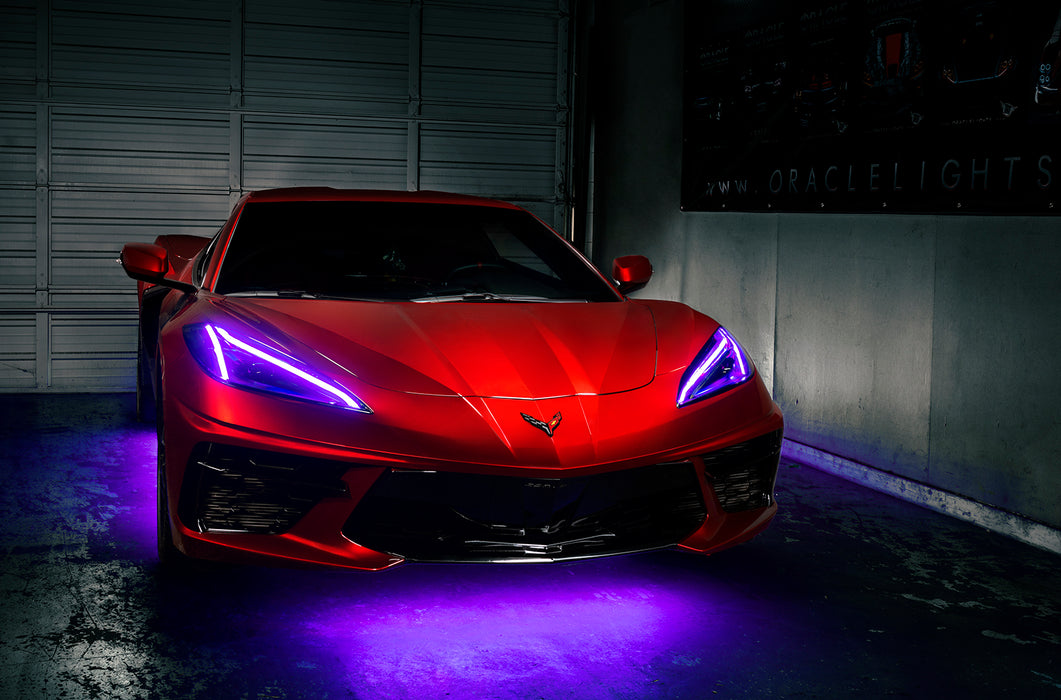 Red Corvette in a garage with purple headlight DRLs.