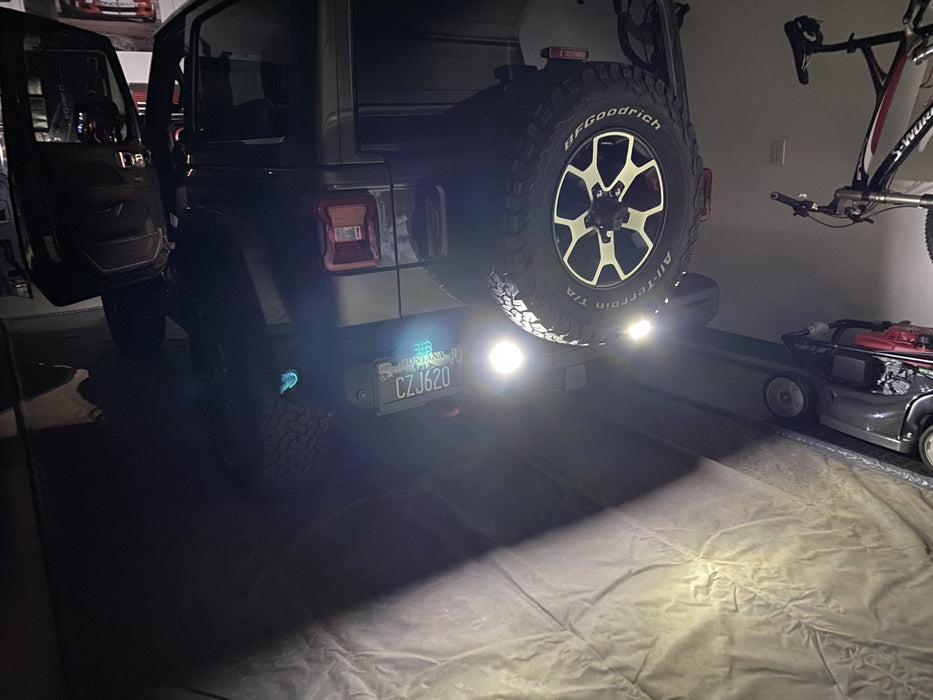 Rear end of a Jeep Wrangler JL with bright reverse lights turned on.
