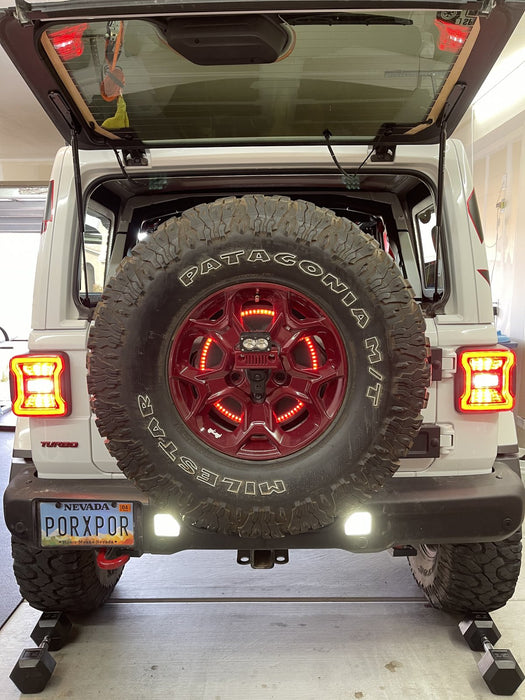 Rear end of a Jeep Wrangler JL with bright reverse lights on.