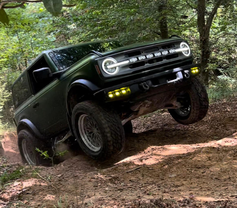 Green Ford Bronco trail riding with yellow Triple LED Fog Lights.