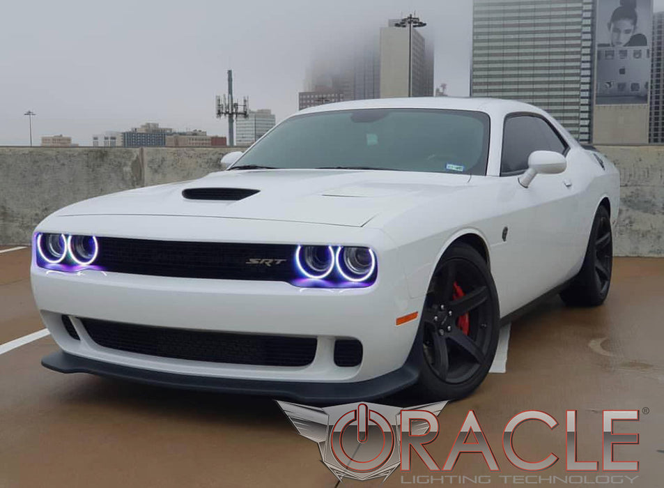 Three quarters view of a white Dodge Challenger with white LED headlight and fog light halo rings installed.