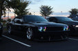 Three quarters view of a black Dodge Challenger with Dynamic ColorSHIFT Headlight Halo Kit installed.