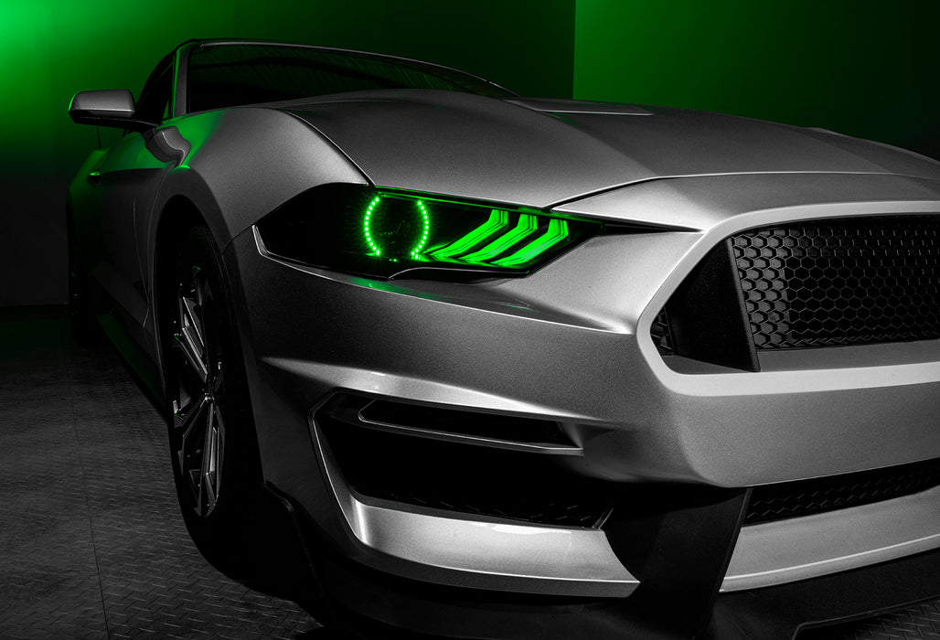 Close-up on a Ford Mustang headlight with green halos and DRLs.