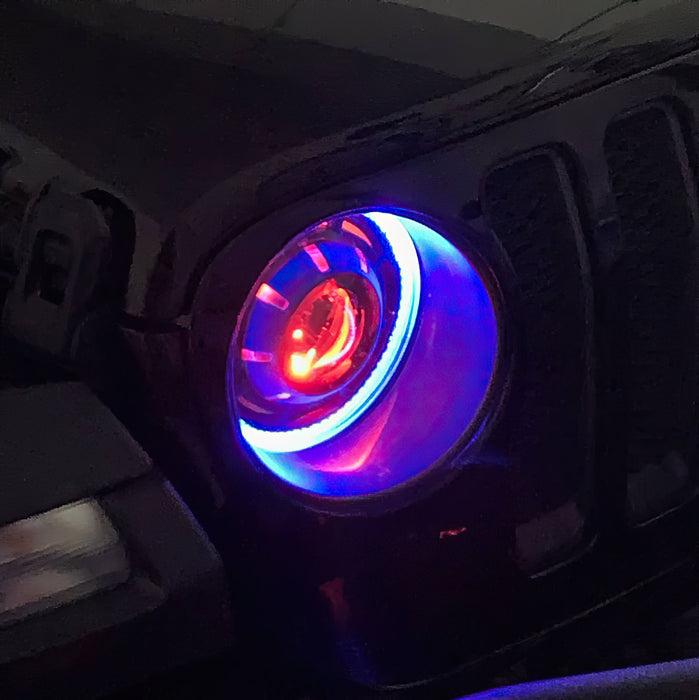 Close-up of an Oculus Headlight installed on a Jeep, with blue outer halos, and red demon eye projector.