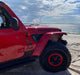 Side view of a Jeep Wrangler parked by the ocean, with Sidetrack™ LED Lighting System installed.