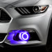 Close-up on the front bumper of a silver Ford Mustang equipped with purple fog light halos.