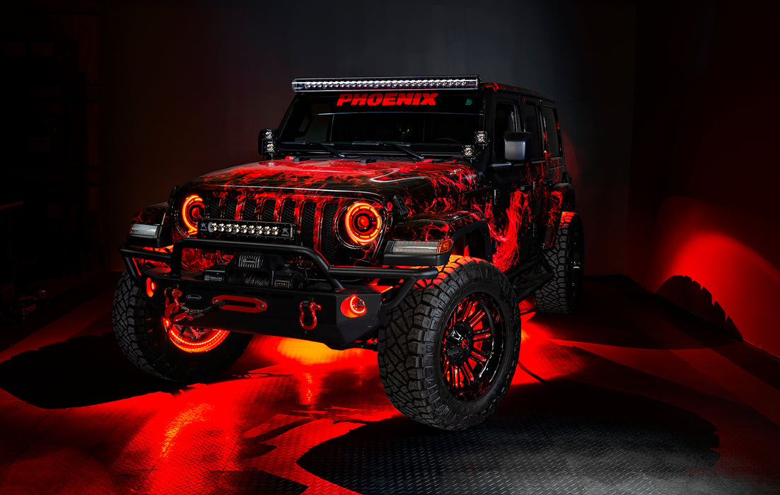 Three quarters view of a red Jeep Wrangler JL, with ColorSHIFT Oculus Headlights, and red halo rings.