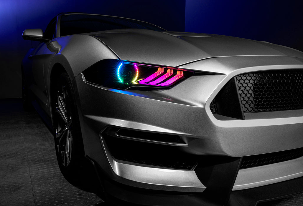 Close-up on a Ford Mustang headlight with rainbow halos and DRLs.