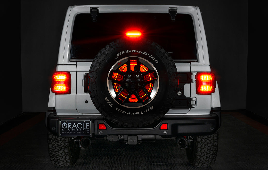 Rear end of a white Jeep with LED Illuminated Spare Tire Wheel Ring Third Brake Light installed.