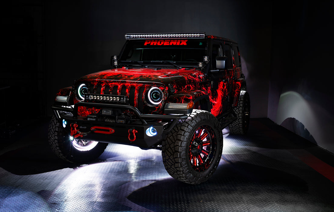 Three quarters view of a red Jeep Wrangler JL with High Performance 20W LED Fog Lights installed, and white halos on.