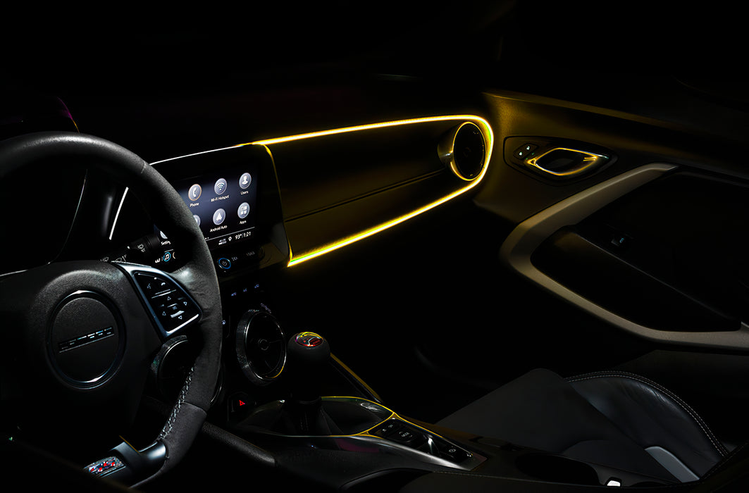Car interior with yellow fiber optic lighting installed on the dashboard.