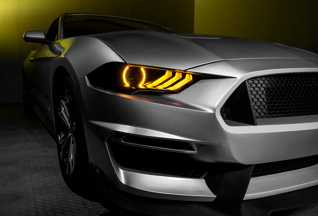 Close-up on a Ford Mustang headlight with yellow halos and DRLs.