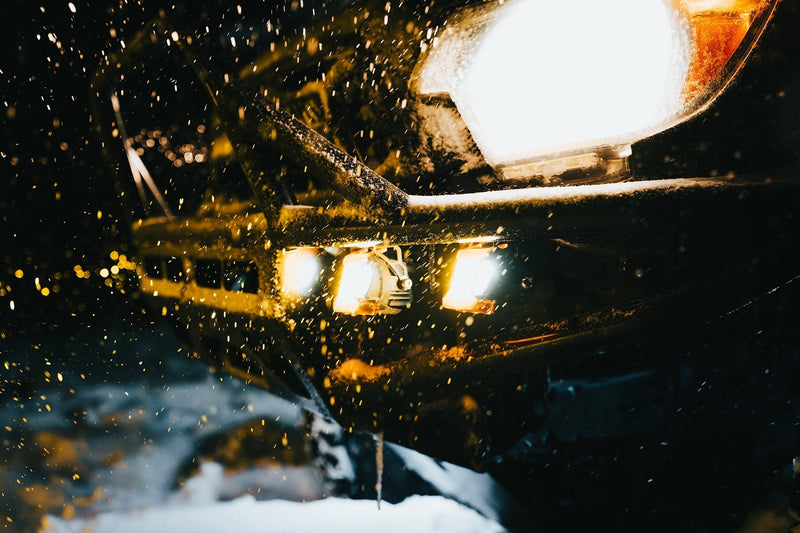 Winter Driving Visibility: How White, Yellow, and Amber Lighting Improve Safety on the Road - close-up of vehicle lights in snow