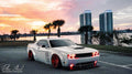 Three quarters view of a white Dodge Challenger with red LED headlight and fog light halo rings installed.