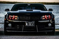 Front end of a Chevrolet Camaro with red LED headlight halo rings installed.