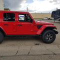 Side view of a red Jeep with Sidetrack™ LED Lighting System installed.