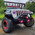 Front end of a Jeep with ColorSHIFT Oculus Headlights installed, with pink halo rings.