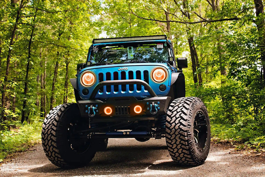 Front end of a Jeep Wrangler JK with amber LED headlight and fog light halos installed.